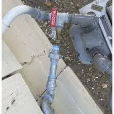 Close-up image of a plumbing setup with various pipes and a valve, installed by Mason Plumbing, Inc. in San Anselmo.